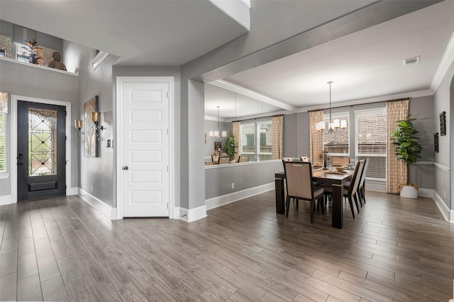 dining room featuring wood-type flooring, ornamental molding, and an inviting chandelier