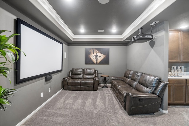 carpeted home theater featuring a tray ceiling and crown molding