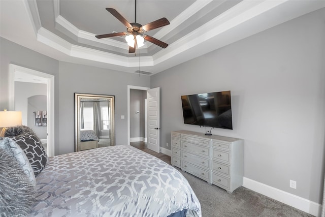 bedroom with a tray ceiling, ornamental molding, ceiling fan, and carpet flooring