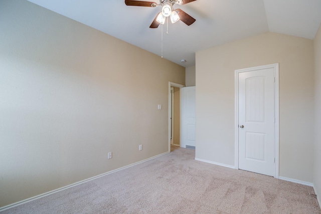 unfurnished bedroom featuring lofted ceiling, light colored carpet, and ceiling fan