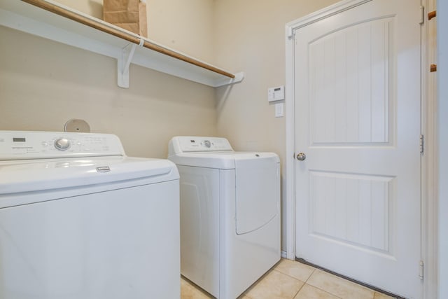 laundry room with washing machine and dryer and light tile patterned floors