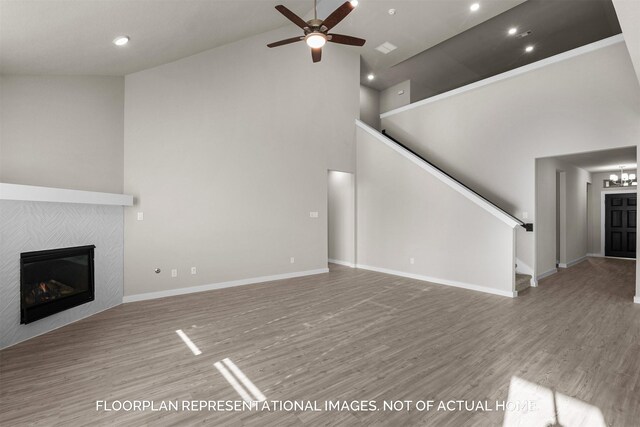 unfurnished living room with ceiling fan, high vaulted ceiling, hardwood / wood-style floors, and a fireplace