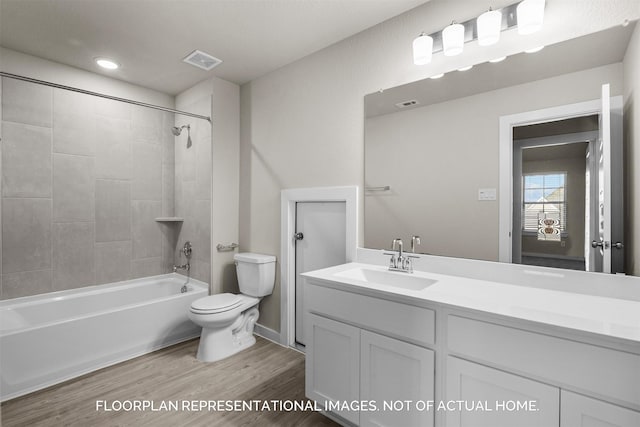 bathroom featuring visible vents, toilet, washtub / shower combination, vanity, and wood finished floors