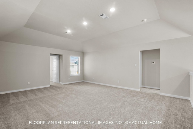 unfurnished room with vaulted ceiling, light carpet, visible vents, and baseboards