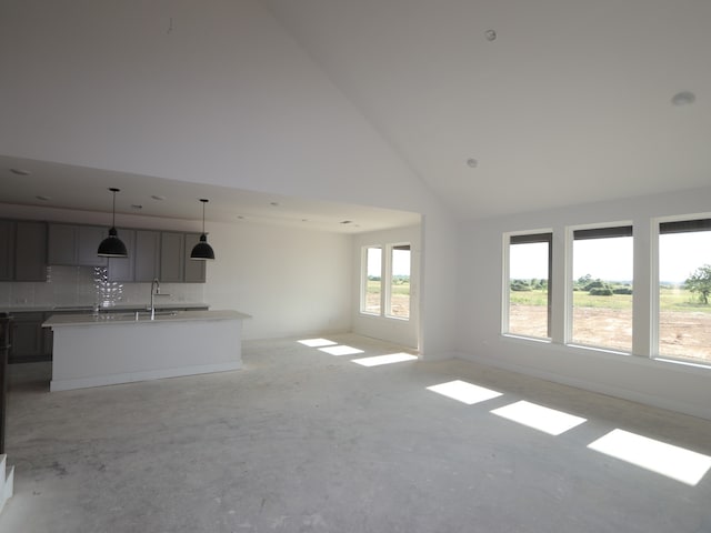 8411 Oceanmist Cove Dr, Cypress, TX 77433 - unfurnished living room featuring high vaulted ceiling, a sink, unfinished concrete floors, and baseboards