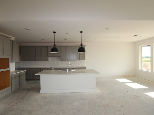 8411 Oceanmist Cove Dr, Cypress, TX 77433 - kitchen featuring a sink, a kitchen island with sink, decorative backsplash, and gray cabinetry