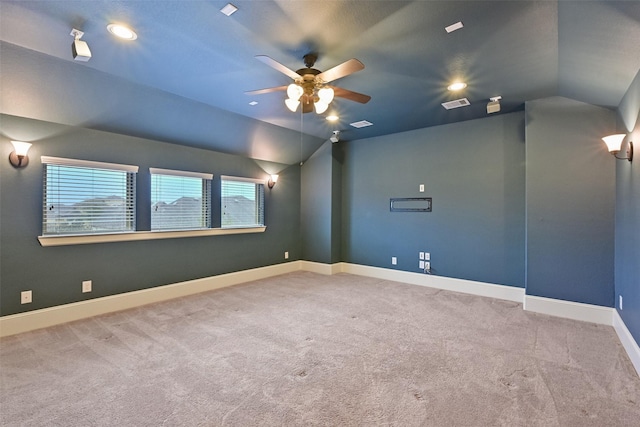 spare room featuring lofted ceiling, light carpet, and ceiling fan