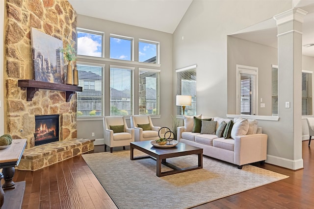 living room with a fireplace, wood-type flooring, plenty of natural light, and ornate columns