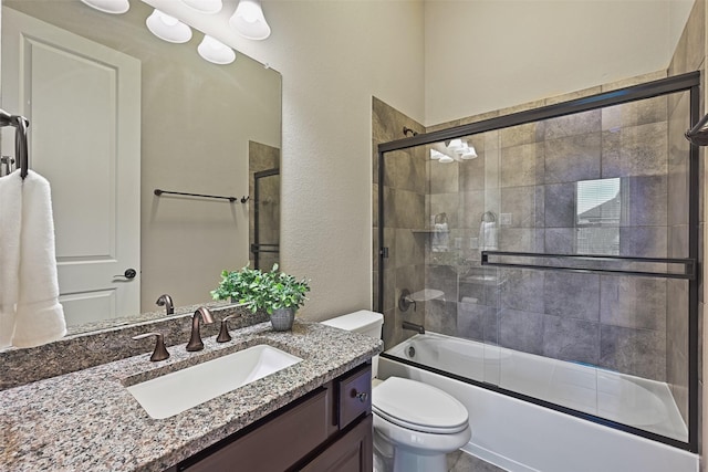 full bathroom with vanity, toilet, and combined bath / shower with glass door