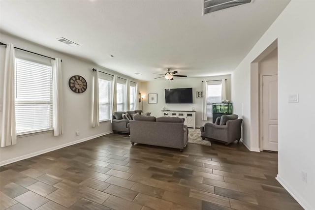 living room featuring wood finish floors, visible vents, ceiling fan, and baseboards