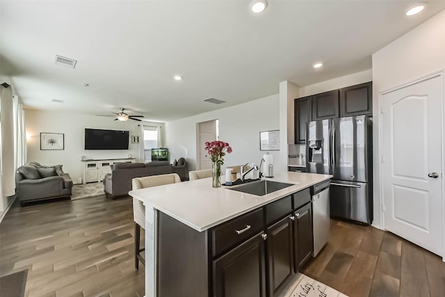 kitchen with appliances with stainless steel finishes, dark wood-type flooring, a sink, and visible vents