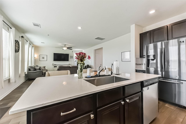 kitchen with stainless steel appliances, light countertops, a sink, and visible vents