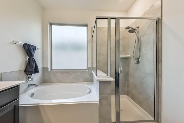 bathroom with a stall shower, a garden tub, and vanity