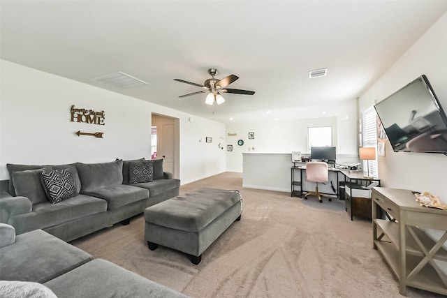 living area featuring light carpet, visible vents, and a ceiling fan