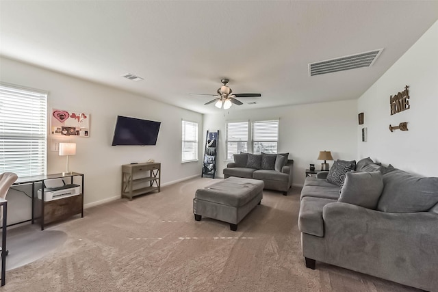 living area with carpet floors, baseboards, visible vents, and a ceiling fan