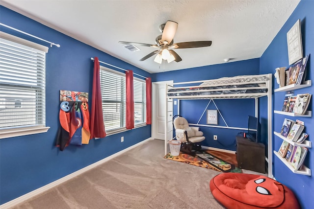 carpeted bedroom featuring a ceiling fan, visible vents, a textured ceiling, and baseboards