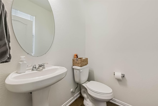 bathroom featuring toilet and baseboards