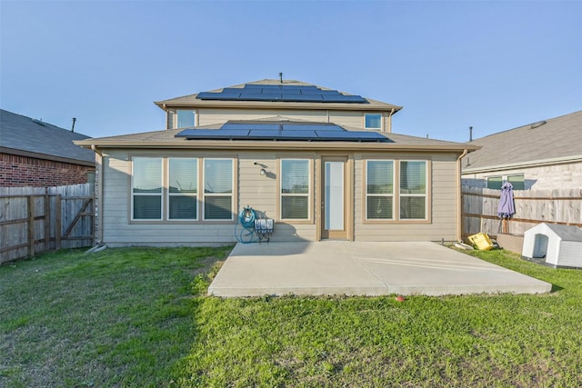 back of house featuring solar panels, a lawn, a patio area, and a fenced backyard