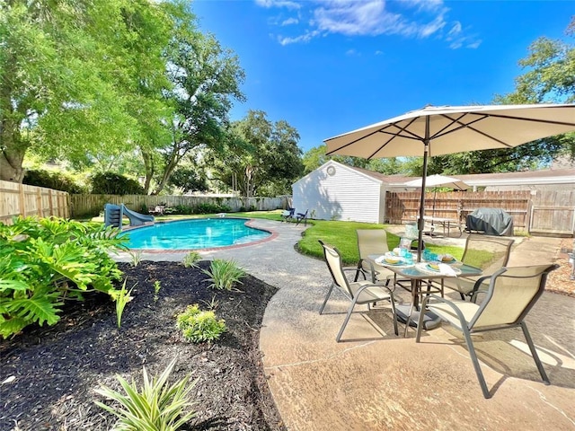 view of swimming pool featuring a water slide, grilling area, and a patio area