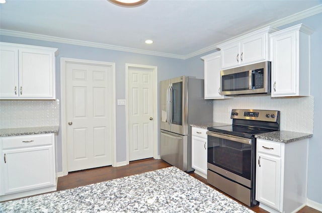 kitchen featuring white cabinets, light stone counters, stainless steel appliances, and backsplash