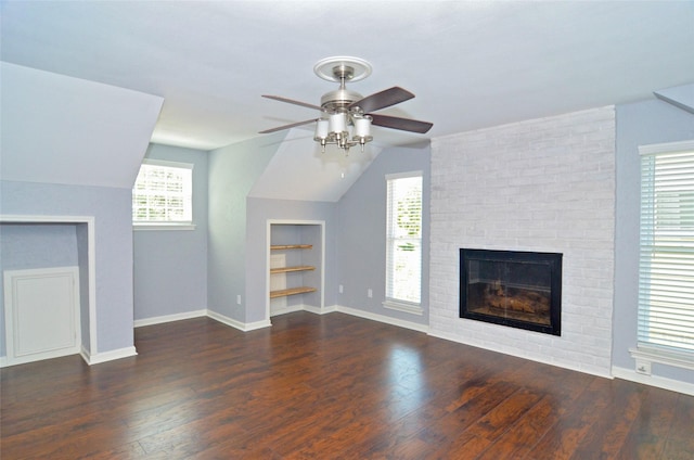 unfurnished living room with a fireplace, built in features, vaulted ceiling, and dark wood-type flooring