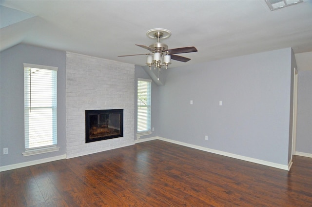 unfurnished living room with lofted ceiling, dark wood-style flooring, a fireplace, visible vents, and baseboards