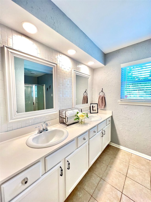 bathroom with double vanity, tile patterned flooring, a sink, and a textured wall