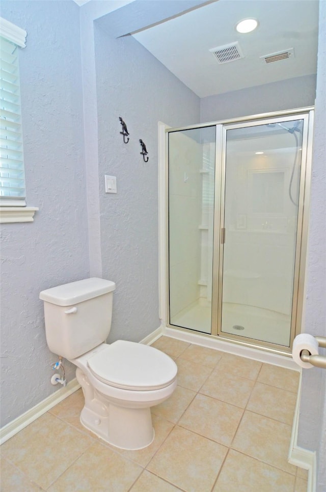 bathroom featuring a stall shower, visible vents, a textured wall, toilet, and tile patterned flooring