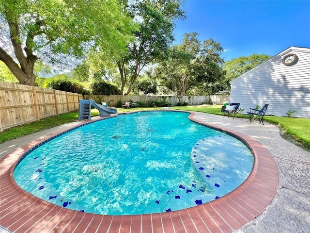 view of swimming pool with a fenced in pool, a water slide, a fenced backyard, and a patio