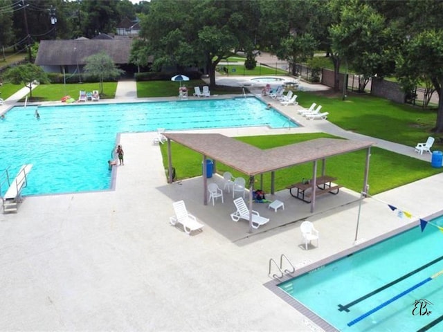 pool featuring a patio, a lawn, and fence