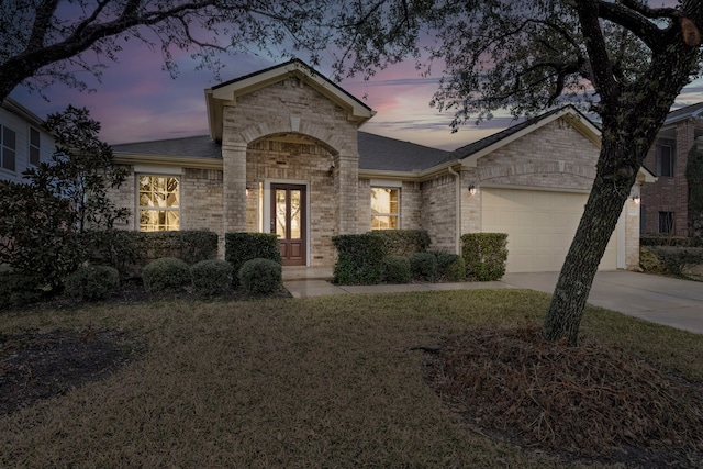 single story home with a garage and a lawn