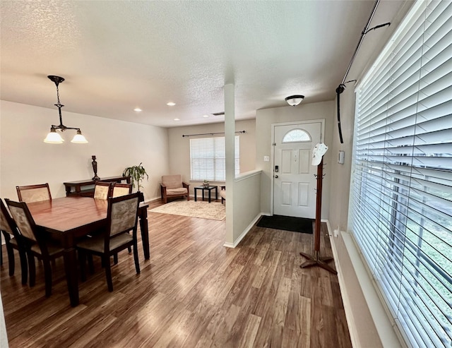 dining area with hardwood / wood-style flooring and a textured ceiling