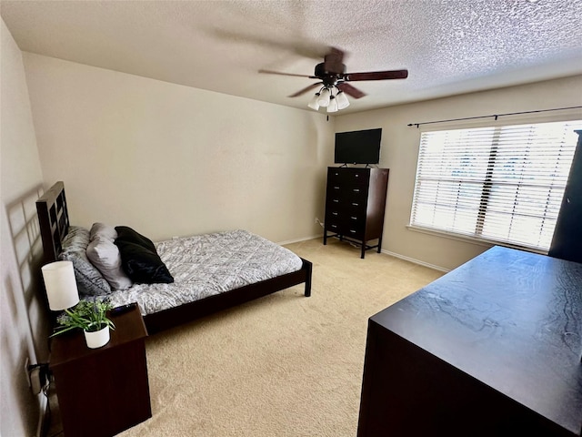 carpeted bedroom featuring ceiling fan and a textured ceiling