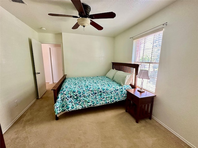 bedroom with a textured ceiling, ceiling fan, and carpet