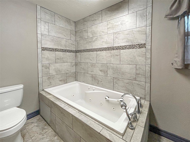 full bathroom with baseboards, toilet, a textured ceiling, and a tub with jets