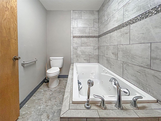 full bath featuring baseboards, toilet, a textured ceiling, and a tub with jets