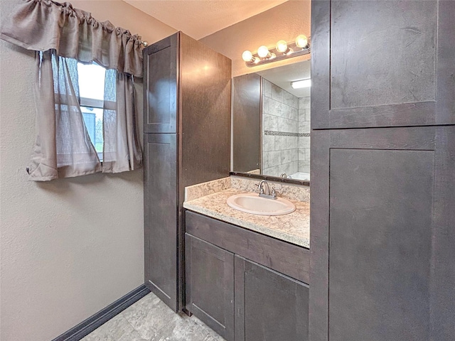 full bathroom featuring baseboards and vanity