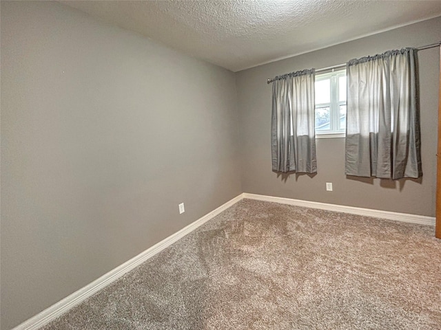 unfurnished room featuring carpet floors, baseboards, and a textured ceiling