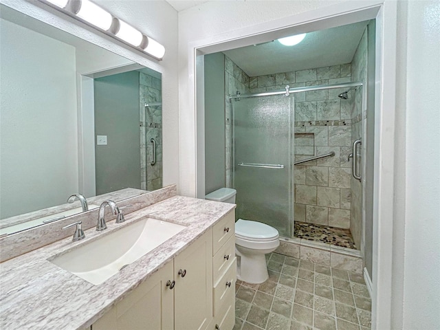 full bathroom with toilet, a stall shower, and vanity