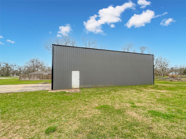 view of pole building with a yard and fence