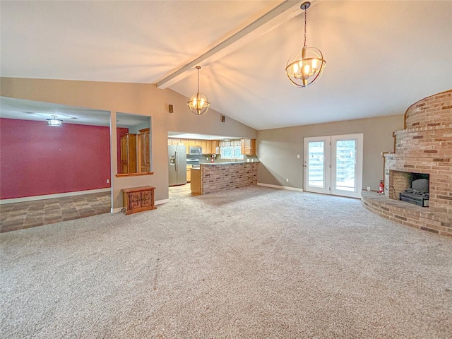 unfurnished living room featuring lofted ceiling with beams, carpet floors, a fireplace, and a notable chandelier