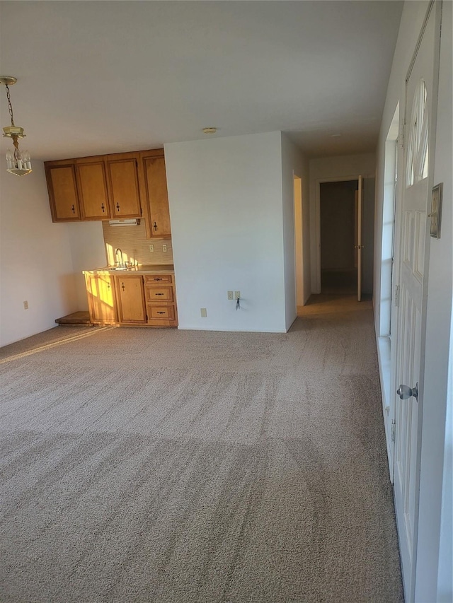 unfurnished living room with sink and light carpet