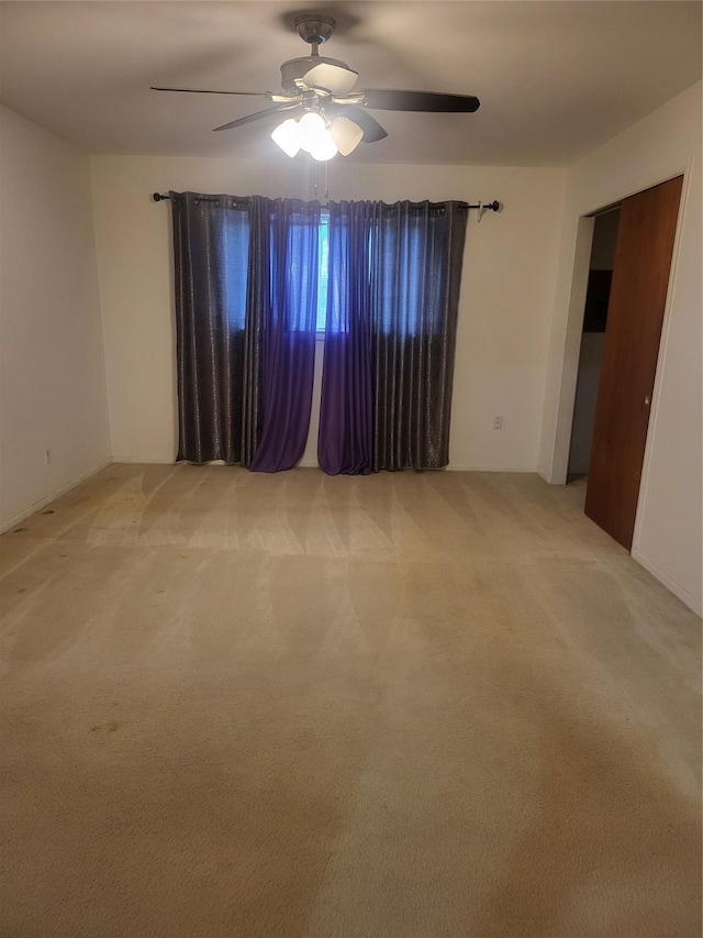 carpeted spare room with ceiling fan