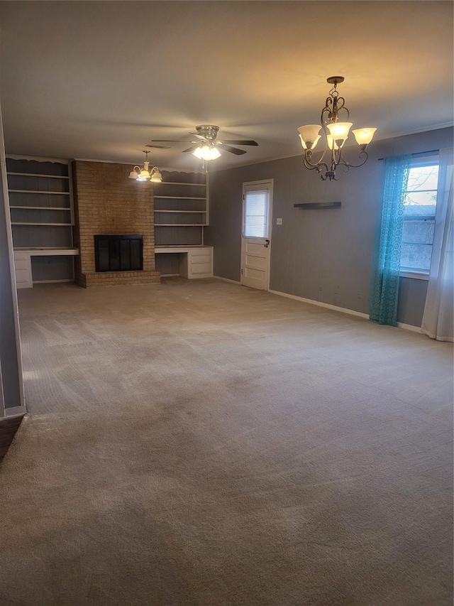 unfurnished living room featuring crown molding, a brick fireplace, carpet flooring, and ceiling fan with notable chandelier