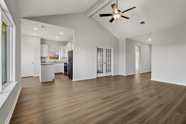 unfurnished living room featuring high vaulted ceiling, beamed ceiling, hardwood / wood-style flooring, ceiling fan, and french doors