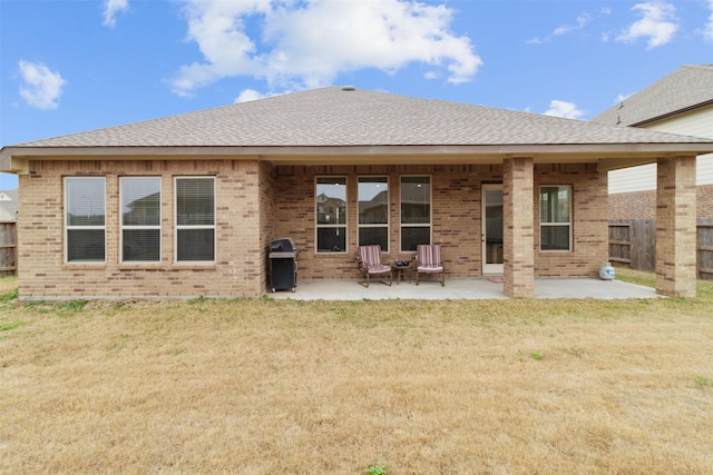 rear view of property featuring a patio and a yard