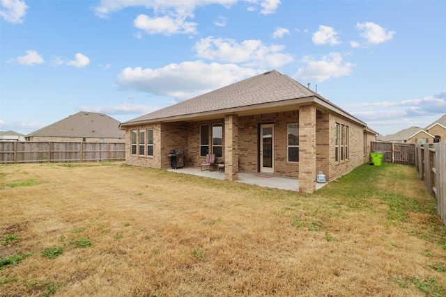 rear view of property with a yard and a patio