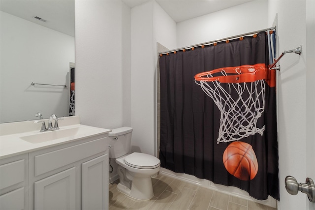 bathroom featuring vanity, walk in shower, and toilet