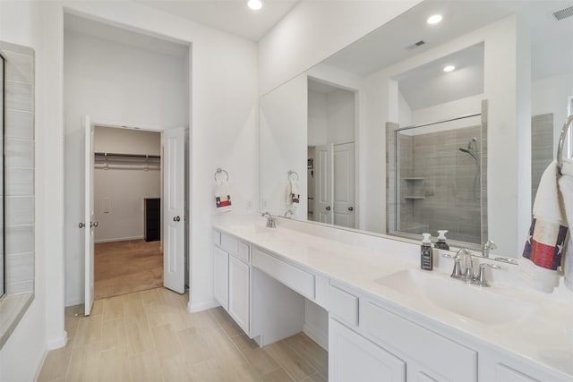 bathroom featuring vanity and a shower with door