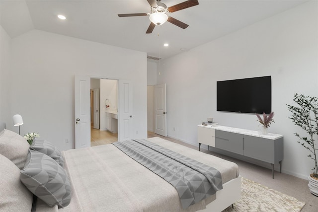 carpeted bedroom featuring vaulted ceiling, ensuite bathroom, and ceiling fan